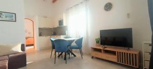 a living room with a table with chairs and a television at Apartments Sara in Bale