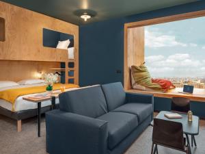 - une chambre avec un canapé, un lit et une fenêtre dans l'établissement Eklo Nantes Centre Ile de Nantes, à Nantes