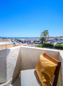 a chair with a pillow sitting on a balcony at Sunbay Casablanca Apartment Javea Arenal by Rock Rentals in Platja de l'Arenal