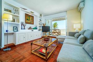 a living room with a couch and a glass table at Sunbay Casablanca Apartment Javea Arenal by Rock Rentals in Platja de l'Arenal