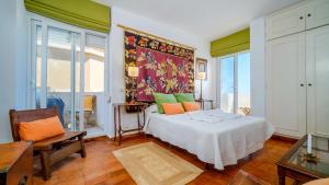 a bedroom with a large white bed with colorful pillows at Sunbay Casablanca Apartment Javea Arenal by Rock Rentals in Platja de l'Arenal +26 photos