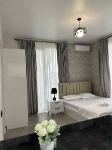 Un dormitorio con una cama y un jarrón de flores. en Shine Hill შაინ ჰილი, en Tsinsvla