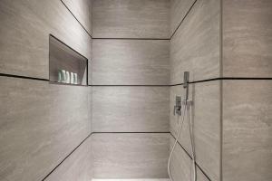 Un baño con ducha con puerta de cristal. en Studio with Balcony and Coworking Space in The Autograph JVC, en Dubái