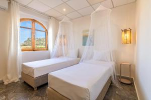 two beds in a room with a window at Villa Zoi in Sissi