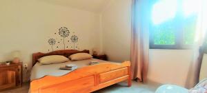 a bedroom with a wooden bed and a window at Apartments Sara in Bale