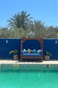 eine Couch neben einem Pool in der Unterkunft Villa Majorelle à Tezdaine in Djerba
