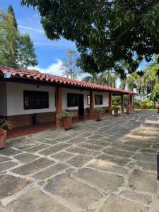 a building with a stone patio in front of it at Finca Las Palmas San Gil in San Gil
