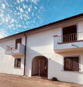 a white building with two balconies and a gate at Your Exclusive Apartment near Santa Teresa Gallura in Porto Pozzo +9 photos