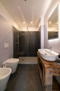 a bathroom with a sink and a toilet and a shower at Lussari Style Apartments in Tarvisio