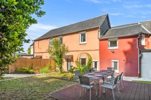 ルーアンにあるMaison Calme avec Jardin - 10 pers - Proche Centre Rouenの家の前にテーブルと椅子が置かれたパティオ