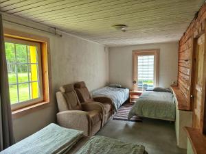 a room with two beds and a couch and a window at Elly Kodumajutus Kihnus in Linaküla
