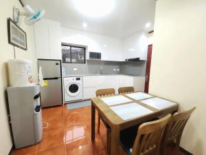 a small kitchen with a table and a refrigerator at UKG Residence in Liloan