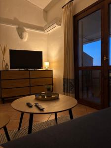 a living room with a coffee table and a television at Appartamento Mare e Natura in Castelsardo