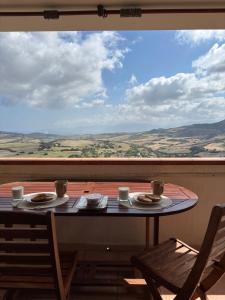 a table with plates of food on a balcony at Appartamento Mare e Natura in Castelsardo