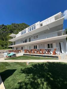a large white building with a lawn in front of it at Hotel Familja Çuni Theth in Theth