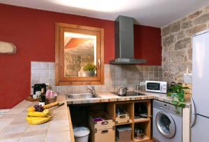 una cucina con lavello e lavatrice di Patio con barbacoa - Casa de las Letras a Lledó