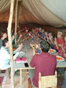 un gruppo di persone sedute intorno a un lungo tavolo di Campement Akka Nait Sidi - Tissint a Tissint