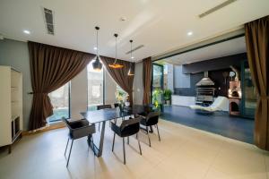 a dining room and living room with a table and chairs at Sila Anila 7BRs Pool Villa My Khe Beach Da Nang in Da Nang