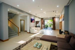 a living room with a couch and a table at Sila Anila 7BRs Pool Villa My Khe Beach Da Nang in Da Nang