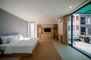 a bedroom with a large bed and a television at Sila Anila 7BRs Pool Villa My Khe Beach Da Nang in Da Nang +85 photos