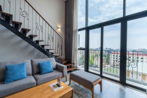 a living room with a couch and a large window at Luxury Pentstudio Westlake - Tay Ho, Ha Noi in Hanoi