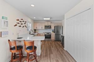 a kitchen with a white counter and two chairs at Chipps Ahoy in Oak Island +39 photos