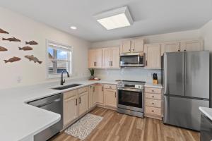 a kitchen with stainless steel appliances and wooden cabinets at Chipps Ahoy in Oak Island