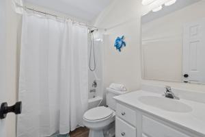a white bathroom with a toilet and a shower at Chipps Ahoy in Oak Island