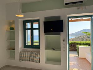 ein Zimmer mit einem Fenster und einem Fernseher an der Wand in der Unterkunft Lipsi Blue Hotel in Lipsi