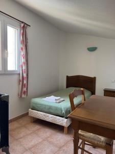 a bedroom with a bed and a table and a window at Ferme de Sejour Rebuffel in La Roque-Esclapon