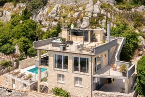 a house on the side of a mountain at Holiday Home La Montagna - Private Heated Pool in Lokva Rogoznica