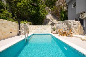 a swimming pool next to a house at Holiday Home La Montagna - Private Heated Pool in Lokva Rogoznica +106 photos
