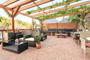 un patio al aire libre con sofás, mesas y sillas en Villa Vici - Ferienwohnungen, en Merschbach