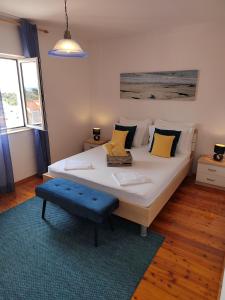 a bedroom with a large white bed with yellow pillows at Apartments Marina in Hvar