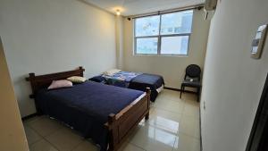 two beds in a small room with a window at Condominio 25 in Santa Cruz de la Sierra