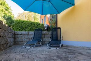 two chairs sitting under an umbrella on a patio at Ferienwohnung Naturnah Ebermannstadt in Ebermannstadt