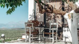 a table and chairs sitting next to a tree at Evnia Sunset Crete Escape, Private HotTub Retreat in Rotásion