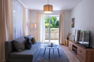 a living room with a couch and a tv and a table at Ferienwohnung Naturnah Ebermannstadt in Ebermannstadt