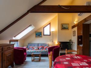 ein Wohnzimmer mit einem Sofa im Dachgeschoss in der Unterkunft Maison Kervégan à 200m de la mer in Pleumeur-Bodou