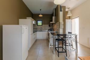 a kitchen with white appliances and black stools at Beau gite avec couloir de nage in Le Garn