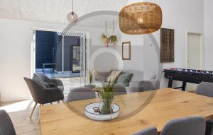 a dining room with a table and a piano at 4 Bedroom Stunning Home In Glesborg in Glesborg