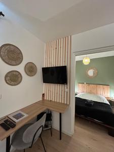 una camera da letto con un letto e una scrivania con una televisione di Studio - 19 a Rochefort-en-Terre