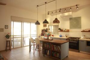 Beʼer OraにあるDesert homeのキッチン(椅子とテーブル付きのカウンター付)