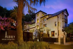 圣地亚哥Aubrey Hotel Boutique的一座带栅栏和树的大型白色房屋