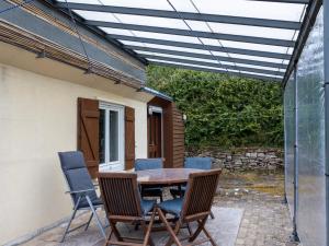 eine Terrasse mit einem Holztisch und Stühlen in der Unterkunft Maison Kervégan à 200m de la mer in Pleumeur-Bodou + 18 Fotos