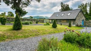 a stone house with a garden in front of it at Bwthyn Ysgubor in Conwy
