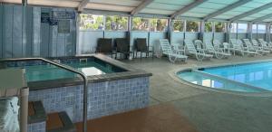 una grande piscina con sedie e tavolo di Seahawk Motel a Virginia Beach