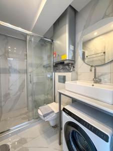 a bathroom with a shower sink and a washing machine at IFESTOS SUITES by SDR in Paralia Katerinis +84 photos
