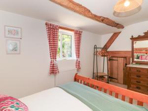a bedroom with a bed and a window at Old Farm Cottage in Warminster