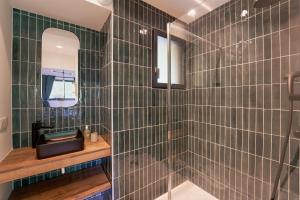 a bathroom with green tiled walls and a shower at Chalet du Cerf in Orcières +25 photos